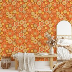 a bedroom with an orange wallpaper and white bed in the foreground, next to a mirror