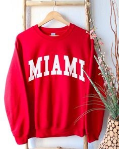 Miami Florida Sweatshirt, Miami Shirt, Miami Crewneck, Miami Sweatshirt for Women, Miami Gifts, Miami Shirts Women * Super soft sweatshirt made of 50% cotton 50% polyester. * Design is high-quality screen printed. * Classic fit - Size up if you want a looser fit. * Unisex sizing - See pictures for size guide. If you have any questions, feel free to message me! Shop Homepage: https://www.etsy.com/shop/peachleafstore/ If you have any issues with your order, please contact me!. *Disclaimer: Since t Crew Neck Tops With Lettering For Winter, Screen Printed Crew Neck Tops, College Style Crew Neck Top With Screen Print, Crew Neck Top With Screen Print For College, Collegiate Style Winter Tops With Screen Print, Varsity Style Winter Top With Lettering, Cotton Varsity Tops With Lettering, Trendy Tops With Lettering For College, Varsity Style Top With Lettering