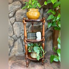 a wooden chair with a plant on top of it in front of a stone wall