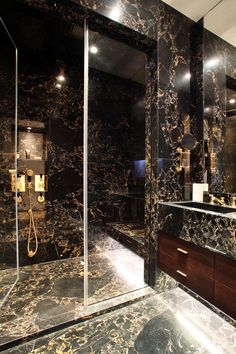 a bathroom with black marble walls and flooring