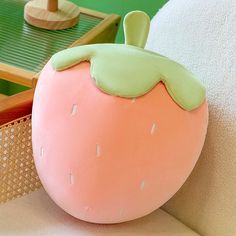 a pink and green pillow sitting on top of a white couch