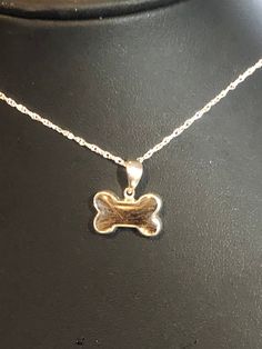 a gold plated necklace with a dog bone on it