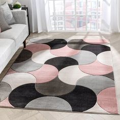 a living room area with a couch, chair and rug on the floor in front of a window