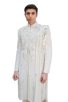 Ivory cotton silk sherwani in mirror and thread work. Paired with mirror work stole and pant.
Component: 3
Pattern: Embroidered
Type Of Work: Mirror work, Thread work
Neckline: Mandarin collar
Sleeve Type: Full sleeves
Fabric: Cotton silk
Color: White
Other Details: 
Pintuck detail
Note: inner kurta worn by the model is not for sale
Occasion: Groom - Aza Fashions White Mirror, Mirror Work, Thread Work, Full Sleeves, Embroidered Silk, Mandarin Collar, Cotton Silk, Aza Fashion, Full Sleeve