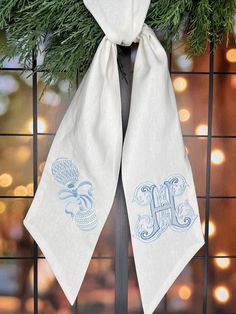 the monogrammed christmas wreath is hung on a door with two white towels hanging from it