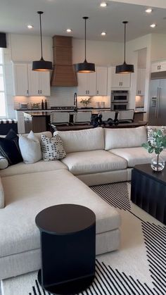 a living room filled with furniture next to a kitchen