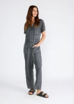 A classic utility-style jumpsuit in an ash grey wash tencel. Tencel Relaxed fit Short sleeve Long straight leg Collared neckline Button front top Zip fly closure Front patch pockets Back patch pocket Utility jumpsuit A jumpsuit to wear on repeat all spring and summer long. Featuring the perfect relaxed fit, our utility-style one-piece is crafted from lightweight tencel and features a button-front top and collared neckline. Short sleeves keep things breezy, while the straight long leg pairs well Utility Style Denim Jumpsuit With Short Sleeves For Work, Short Sleeve Denim Utility Jumpsuit For Workwear, Utility Washed Overalls Jumpsuit, Casual Workwear Overalls With Short Sleeves, Casual Fall Jumpsuits And Rompers With Patch Pockets, Casual Short Sleeve Overalls For Workwear, Casual Overalls For Workwear, Workwear Summer Denim Jumpsuit With Buttoned Pockets, Spring Workwear Washed Jumpsuits And Rompers