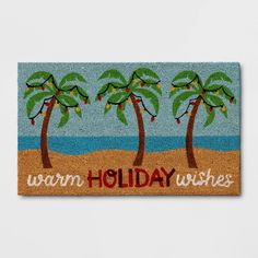 a door mat with three palm trees on it and the words warm holiday wishes written in red