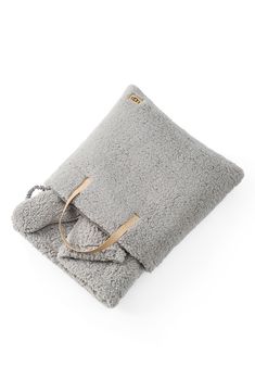 a gray blanket with a pair of glasses on it and a bag in the middle