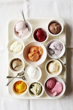 an assortment of ice creams in bowls on a tray