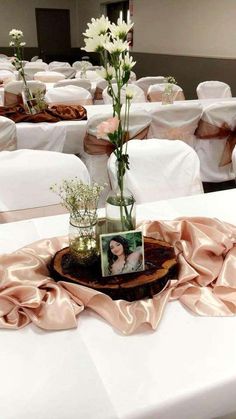 the centerpieces are arranged on top of tables with white chairs and flowers in vases