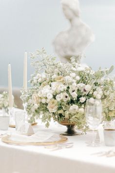 the table is set with white flowers and candles