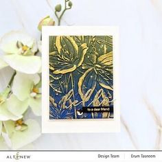 a close up of a card with flowers in the background