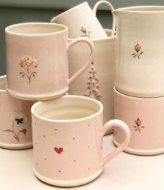 pink and white coffee cups with flowers on them