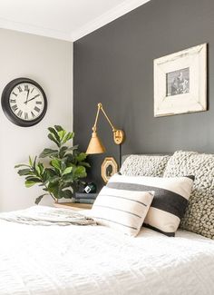 a bedroom with a large bed and clock on the wall