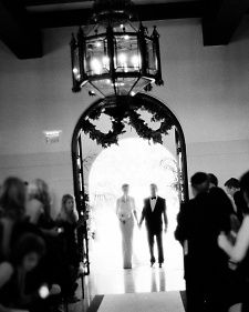 the bride and groom are walking down the aisle to their wedding ceremony in black and white