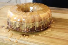 a glazed donut sitting on top of a wooden cutting board