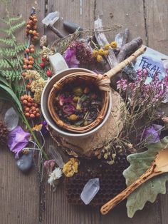 a basket filled with lots of different types of flowers and herbs on top of a wooden table