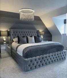 a large bed sitting under a chandelier in a bedroom