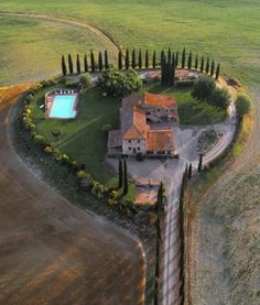 an aerial view of a house with a swimming pool in the middle of a field