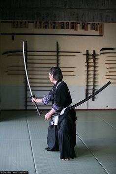 a woman holding two swords in her hands