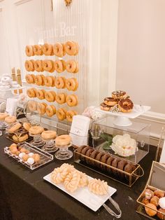 an assortment of doughnuts and pastries displayed on a buffet table at a wedding reception