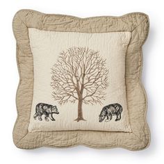 a pillow with two bears on it and a tree in the middle, sitting next to each other