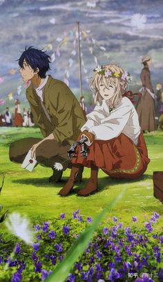 two people sitting on the ground in front of flowers