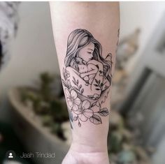 a woman's arm with a tattoo on it and flowers in the background,