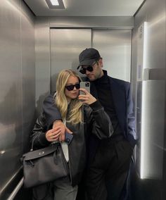 a man and woman taking a selfie in an elevator