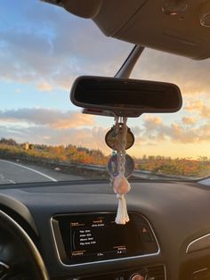 the dashboard of a car with an electronic device hanging from it's dash board