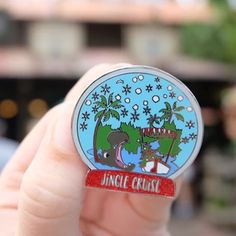 someone is holding up a pin with an image of the jungle cruise logo on it