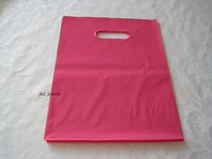 a pink shopping bag sitting on top of a white tablecloth covered floor with paper