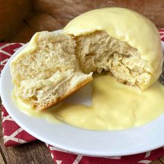 a white plate topped with a doughnut covered in yellow sauce