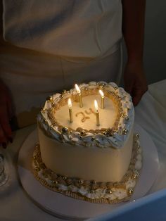 a white cake with three lit candles on it