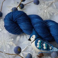 two skeins of blue yarn sitting next to each other on top of snow