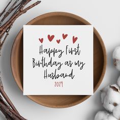 a card that says happy first birthday as my husband on it next to cotton balls