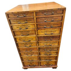 an old wooden cabinet with many drawers and labels on the front, including several letters