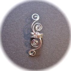 Merlin's Apprentice Sells Ear Cuffs, Ear Wraps, Elven Ears, Elf Ears, Fairy, Goblin and Mermaid Designs. Specializing in Earrings for Non Pierced Ears and Fantasy Jewelry, Custom Orders Welcome!! This listing is for a single ear cuff that can be worn on the left or right ear. Graceful swirls made of silver plated wire wind up and down from the central cuff. Also available in Gold Tone Wire, see last photo. Looking for this listing as a PAIR? order listing https://www.etsy.com/listing/108458182/p Adjustable Spiral Ear Cuff, Silver Adjustable Spiral Wrap Earrings, Silver Spiral Adjustable Ear Cuff, Unique Adjustable Spiral Wrap Earrings, Adjustable Silver Spiral Cartilage Earrings, Elven Ears, Ear Wraps, Mermaid Designs, Ear Cuff Jewelry