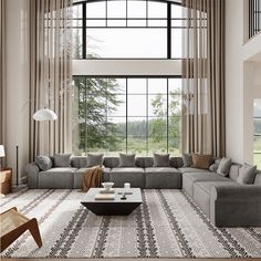 a modern living room with large windows and grey couches