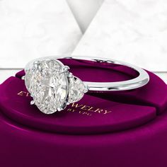 a diamond ring sitting on top of a purple box