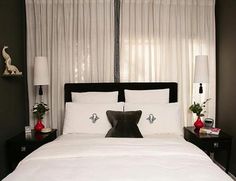 a bed with white sheets and black pillows