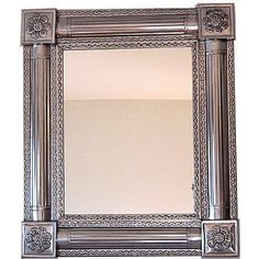 an ornate silver framed mirror on a white wall