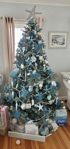 a blue christmas tree with starfish decorations