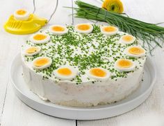 a cake with eggs on top and green sprinkles sitting on a white plate