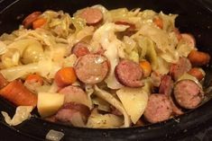 sausage, cabbage and carrots in a slow cooker ready to be cooked for dinner