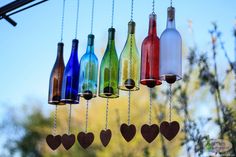 several wine bottles hanging from chains with hearts on them