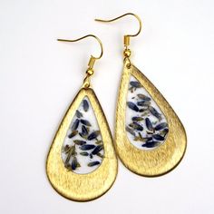 Lavender Teardrop EarringsThese earrings feature real pressed lavender buds, encased  in resin, in a bright brass teardrop shaped setting. Attached to matching hooks and each measures 1.75" x 1" Lavender Teardrop Nickel-free Jewelry, Gift Brass Teardrop Drop Earrings, Gold Teardrop Birth Flower Earrings, Gold Teardrop Jewelry With Pressed Flowers, Gold Teardrop Jewelry With Birth Flower, Gold Teardrop Jewelry With Birth Flower Detail, Pressed Lavender, Flower In Resin, Drop Gold Earrings