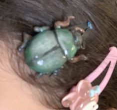 a close up of a child's head with a bug hair clip on it