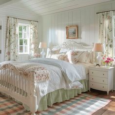 a white bed sitting in a bedroom next to two windows